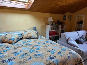 a bedroom with a bed and a couch and a window at LES JARDINS DE CARIBOLE in Fourneaux