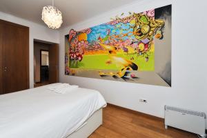 オエイラスにあるOeiras by the beach - Checkinhomeの大きな絵画が壁に描かれたベッドルーム