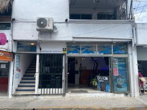 Hostelito Hotel في كوزوميل: مبنى مدخله محل فيه باب