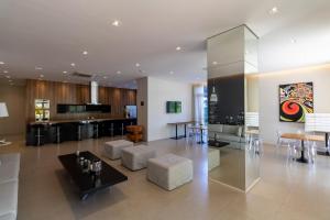 Il comprend un salon avec un mobilier blanc et une cuisine. dans l'établissement 360 Summit Pinheiros, à São Paulo