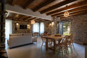 cocina y comedor con mesa y sillas en Lithos Villas Apollon, en Sikia