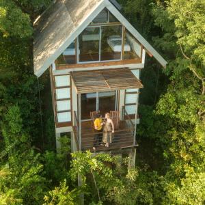due persone in piedi sul portico di una casa sull'albero di Treehouse Chalets a Belihuloya