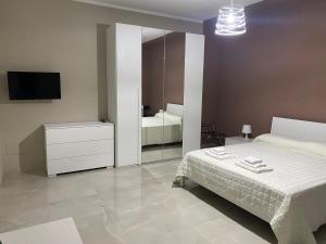 Marconi Rooms and Apartaments في Campobello di Licata: غرفة نوم بسرير وخزانة ومرآة