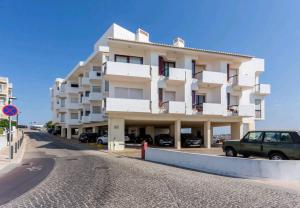 een groot wit gebouw aan de kant van een straat bij welkome OCEAN BREEZE in Portimão