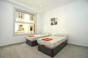 Un dormitorio con dos camas y una ventana. en Bam ! Centro ! Centre ! Zentrum !, en Valencia