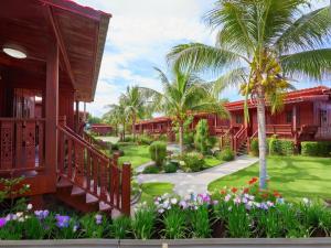 a resort with a garden and palm trees and flowers at SCN Resort and Spa Rayong in Ban Chang