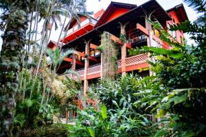 a resort building with a balcony and palm trees at Refúgio do Cacupé in Florianópolis