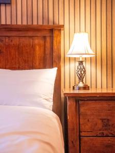 a bedroom with a bed and a lamp on a night stand at Bannerdale Villa - Sheffield in Sheffield