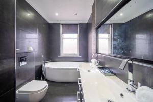 a bathroom with a tub and a toilet and a sink at Bannerdale Villa - Sheffield in Sheffield