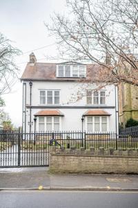 a white house with a fence in front of it at Bannerdale Villa - Sheffield in Sheffield