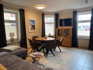 Una sala de estar con un sofá y una mesa con sillas. en Apartmenthaus Zentral Bad Schandau, en Bad Schandau