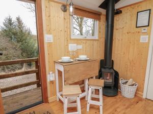 a room with a wood stove in a tiny house at Red Kite at Wild Valley Huts in Oswestry