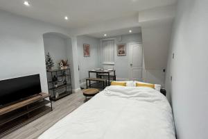een slaapkamer met een wit bed en een flatscreen-tv bij Entire Modern House Close to 2 Stadiums & Town Centre in Liverpool