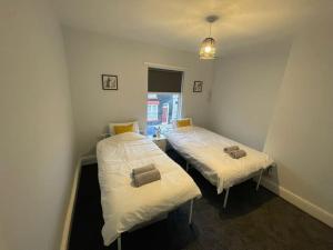 2 aparte bedden in een kamer met een raam bij Entire Modern House Close to 2 Stadiums & Town Centre in Liverpool