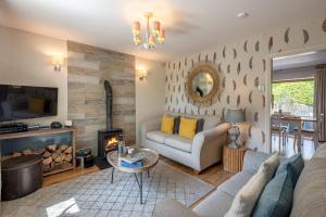 uma sala de estar com um sofá e uma lareira em Woodcroft Cottage em Richmond