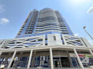 a tall building with a blue sky in the background at NEW!Luxury 1B with balcony in Blue Wave Tower Dubai in Dubai