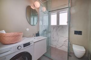 La salle de bains est pourvue d'une douche et d'un lave-linge. dans l'établissement Apollonos apartment, à Athènes