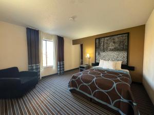 um quarto de hotel com uma cama e uma cadeira em Super 8 by Wyndham Columbia Clark Lane em Columbia