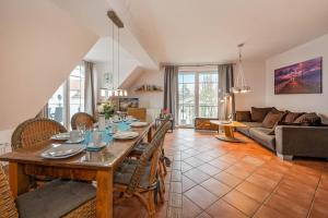 ein Wohnzimmer mit Tisch, Stühlen und Sofa in der Unterkunft Villa Cölpin - Charlotte 03 in Ostseebad Kölpinsee