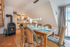 ein Esszimmer mit Tisch und Stühlen und einem Kamin in der Unterkunft Villa Cölpin - Charlotte 03 in Ostseebad Kölpinsee + 15 Fotos