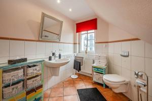 ein Badezimmer mit Waschbecken und Toilette und einem Fenster in der Unterkunft Villa Cölpin - Charlotte 03 in Ostseebad Kölpinsee
