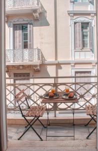 una mesa y sillas en un balcón con un edificio en Apollonos apartment, en Atenas