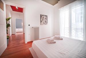 a white bedroom with a bed and a window at Apollonos apartment in Athens
