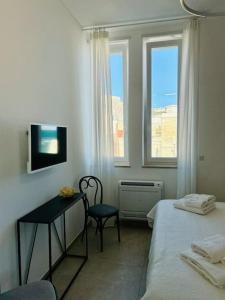 Schlafzimmer mit einem Bett, einem Schreibtisch und einem Fenster in der Unterkunft L'Ancora 2 in Giovinazzo