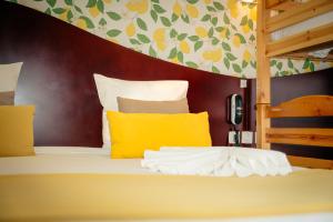 a bedroom with a bed with yellow pillows at Hotel les Commercants in Clermont-Ferrand