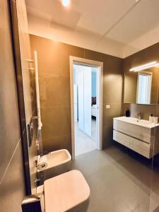 ein Badezimmer mit einem WC, einem Waschbecken und einem Spiegel in der Unterkunft L'Ancora 2 in Giovinazzo