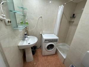 a bathroom with a washing machine and a sink at Magheru City Center Studio in Bucharest