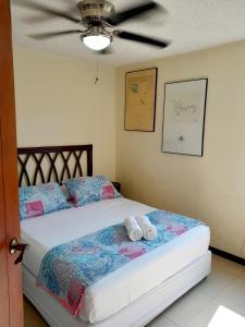 a bedroom with a bed with two towels on it at Family condo, pool, beach and surf in Jacó