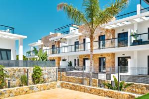 a building with a palm tree in front of it at Sunshine in Pilar de la Horadada