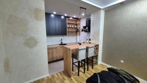 a kitchen with a counter and a bar with stools at PLAY APARTMAN VRSAC in Vršac