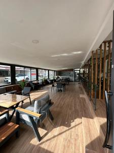 ein Restaurant mit Tischen, Stühlen und Fenstern in der Unterkunft Yade Apart Pension in Ayvalık