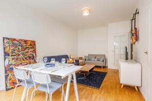 ein Wohnzimmer mit einem weißen Tisch und Stühlen in der Unterkunft Cosy Apartment 4P 1BDR Clichy proche Paris in Clichy