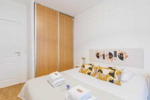 ein Schlafzimmer mit einem weißen Bett und Handtüchern darauf in der Unterkunft Cosy Apartment 4P 1BDR Clichy proche Paris in Clichy