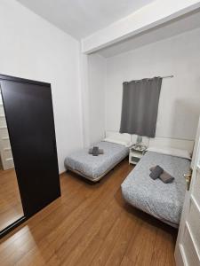 two beds in a room with a door open at Apartamentos Turia in Valencia