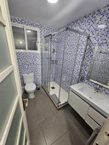 e bagno con servizi igienici, doccia e lavandino. di Apartamentos Turia a Valencia