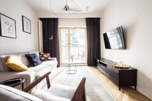 salon z kanapą i telewizorem w obiekcie VipWarsawApartments Amber Mennica Residence w Warszawie