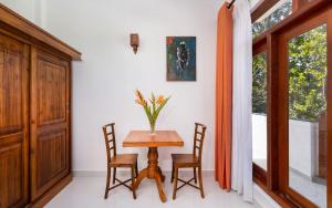 a dining room with a table and chairs and a window at Hotel Southern Blue Sapphire in Induruwa