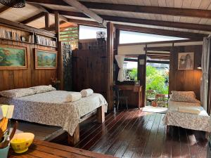 a bedroom with two beds in a room with wooden floors at My Mountain Home in Taravao