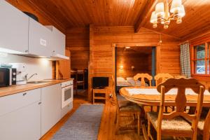 a kitchen and dining room with a table in a cabin at Lomakylä Timitraniemi in Lieksa