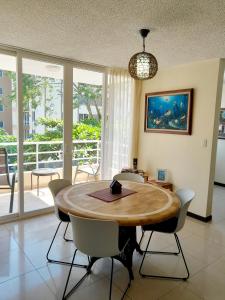 een eetkamer met een houten tafel en stoelen bij Family condo, pool, beach and surf in Jacó