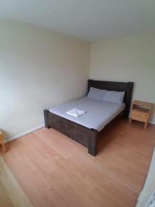 a bed in a room with a wooden floor at Cosy Room by Canary Wharf in London