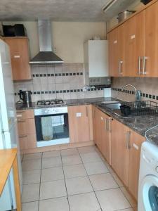 a kitchen with wooden cabinets and an oven at Cosy Room by Canary Wharf in London