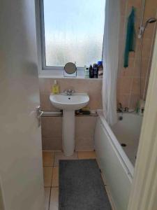 a small bathroom with a sink and a window at Cosy Room by Canary Wharf in London