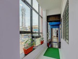 a hallway with a large window with a green rug at Super Collection O Emara Grand Mysore in Mysore