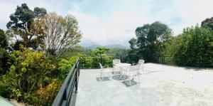 a balcony with two chairs and a table on it at Sithara Estate Bungalow in Ella