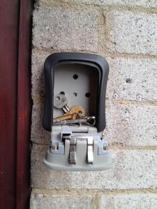 a metal box with keys in a brick wall at Cosy Room by Canary Wharf in London